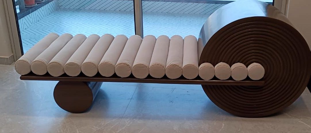 Coiled daybed beside full-height glazing.