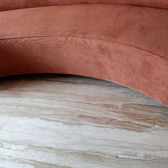Curved rust sofa, close detail of the seat edge.